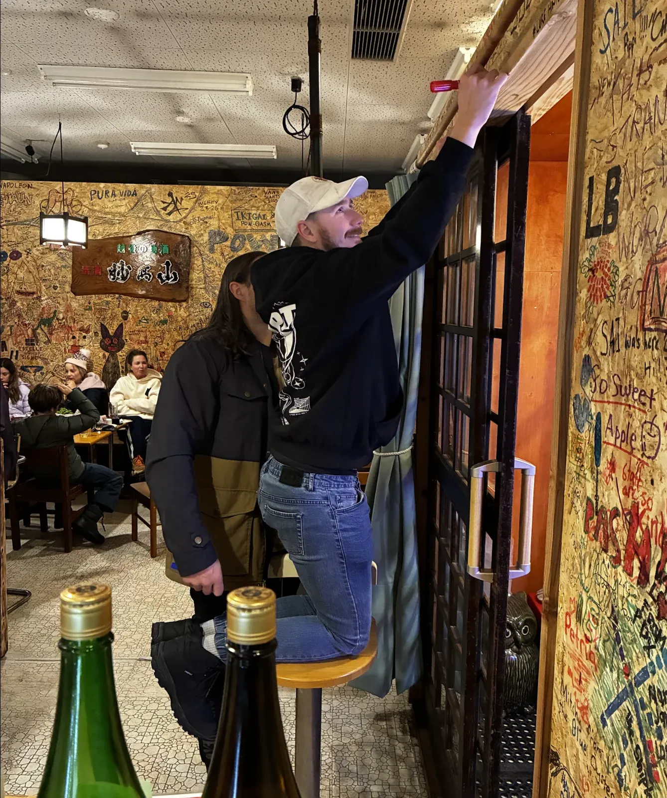 A guest smiling while writing on the NINJA wall