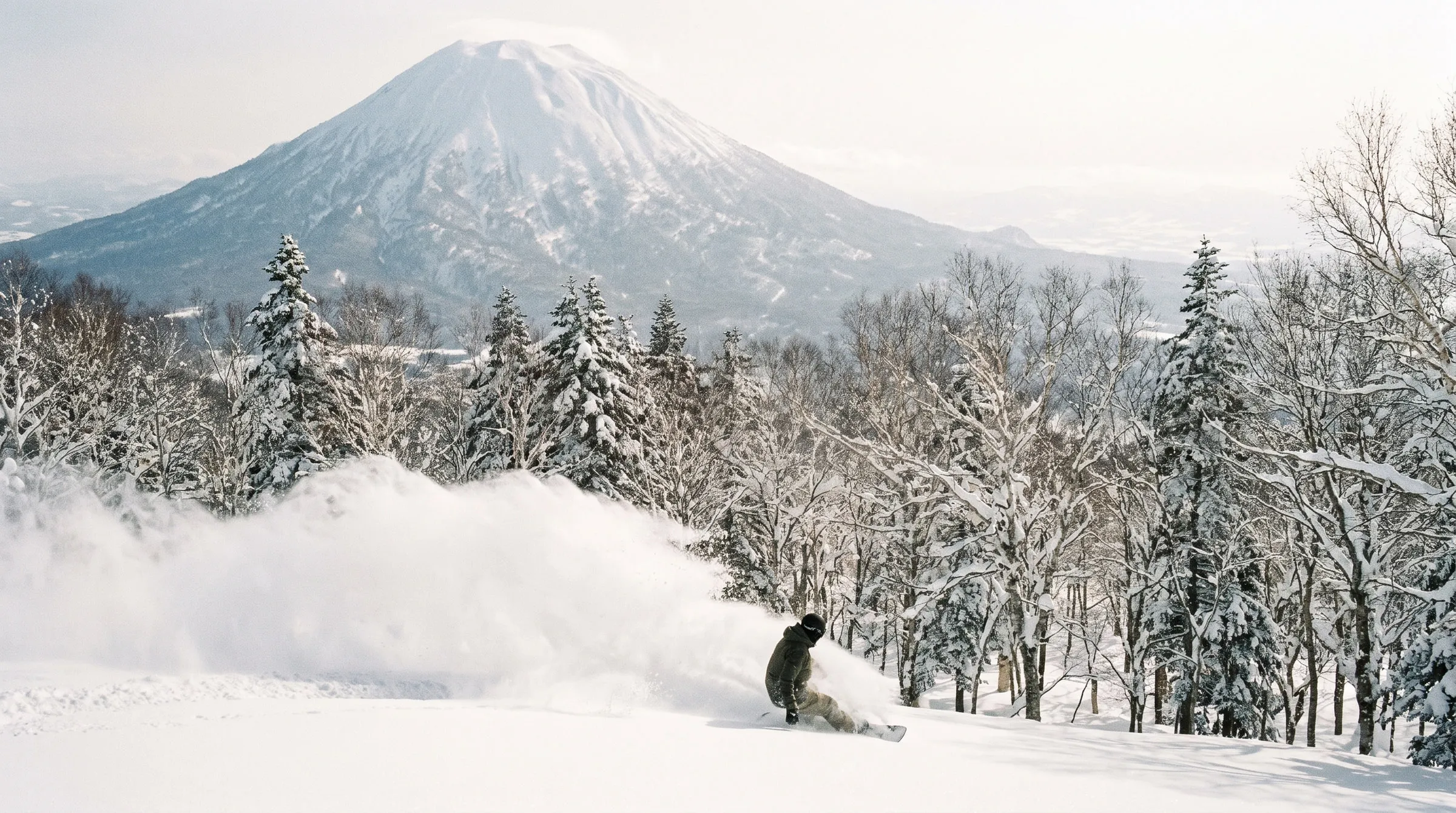 A snowboarder on a powder slope in Myoko