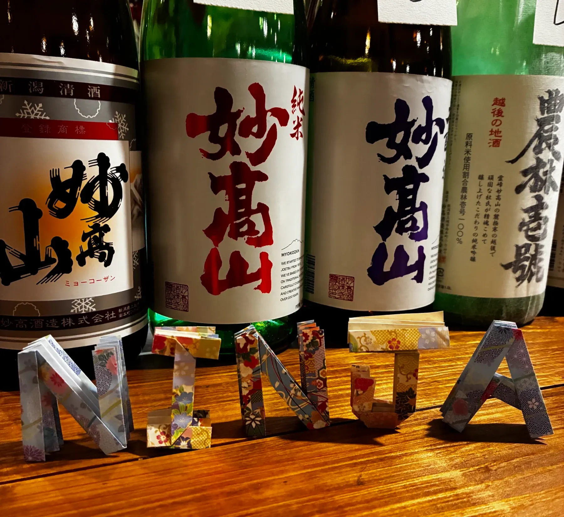 Local sake bottles with origami NINJA letters on the counter